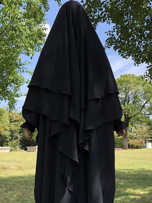 Khimar noir à trois voiles porté en extérieur