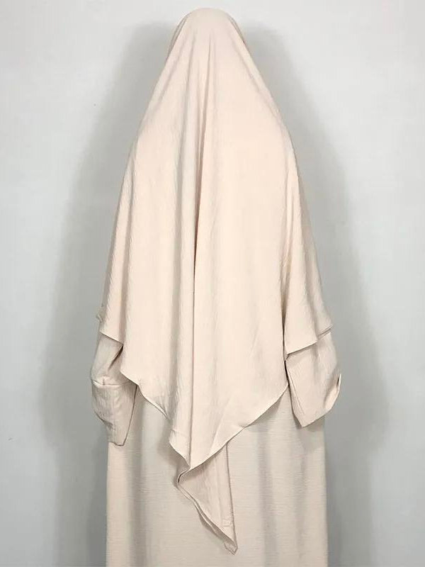 Une femme avec un jolie khimar de couleur beige