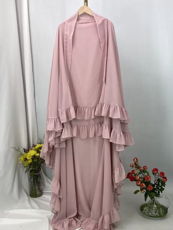 Khimar long à volants étagés rose poudré présenté sur cintre, vue de face avec deux lanières au col