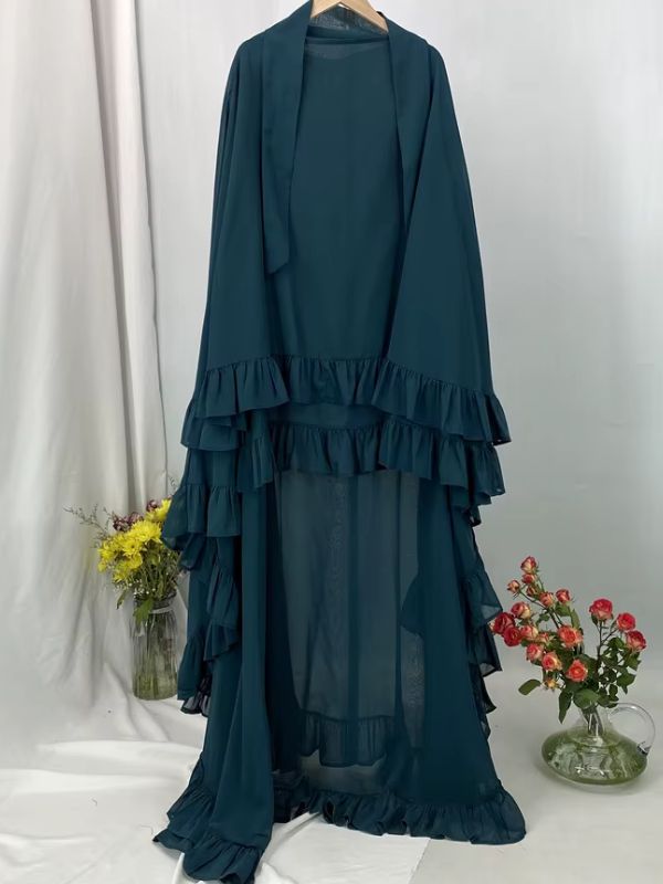 Khimar long à volants étagés vert canard présenté sur cintre, vue de face avec deux lanières au col