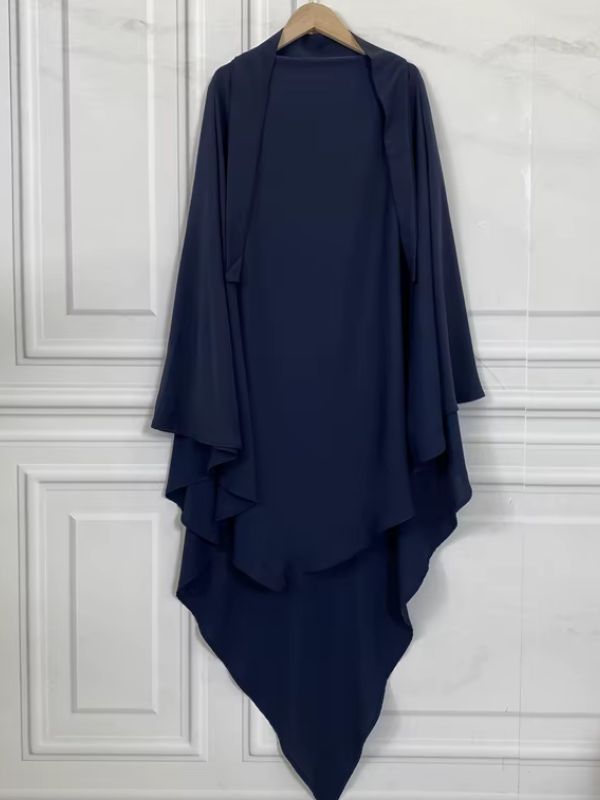 Khimar bleu marine sur cintre en bois, silhouette fluide à double drapé