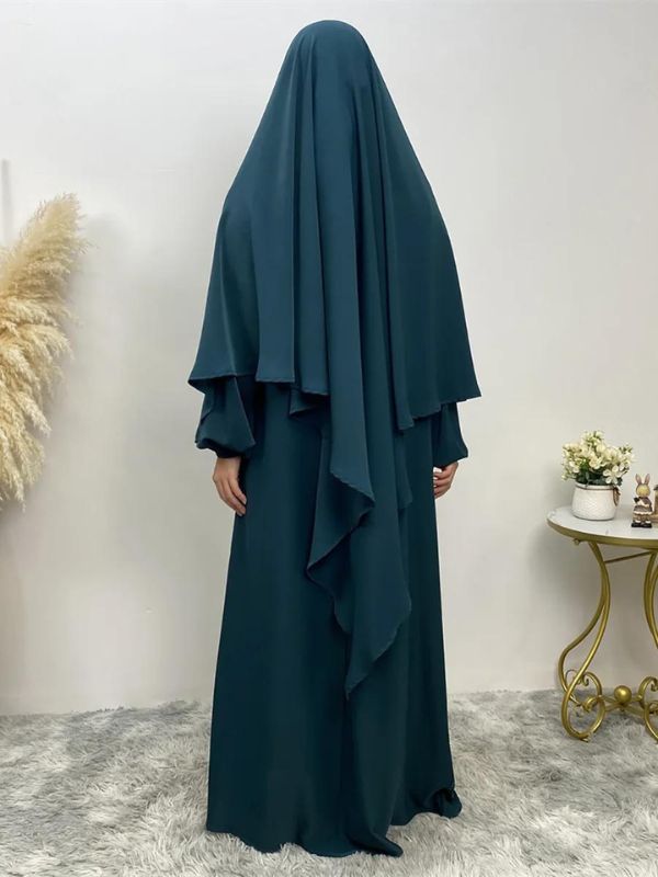 Femme qui porte une abaya et un khimar assorti de couleur emeraude