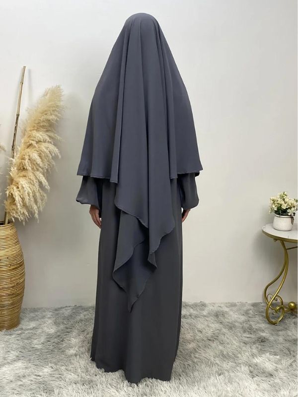 Une femme porte un khimar de couleur gris foncé