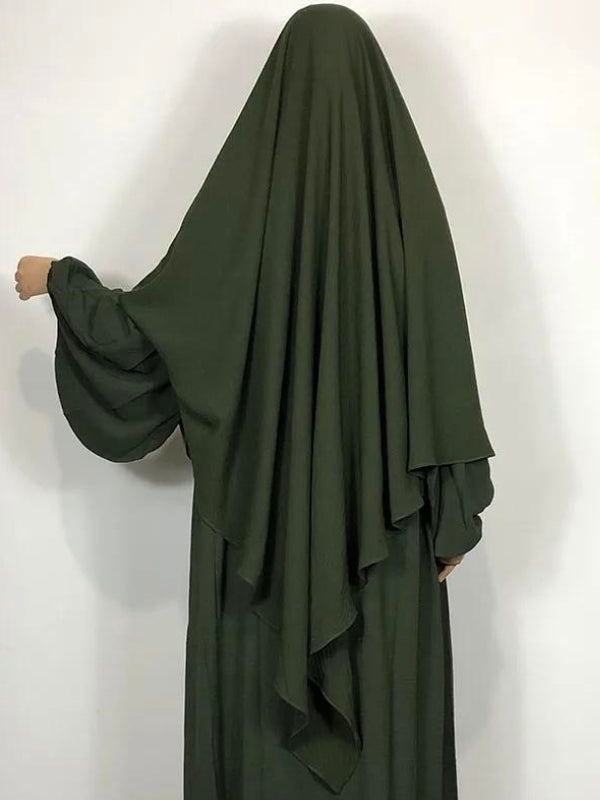 Une femme porte un khimar long de couleur vert foncé