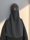 Une femme porte un niqab gris