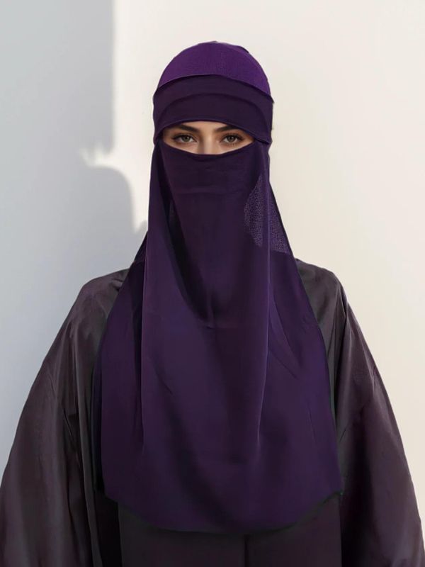 Une femme porte un niqab violet prune