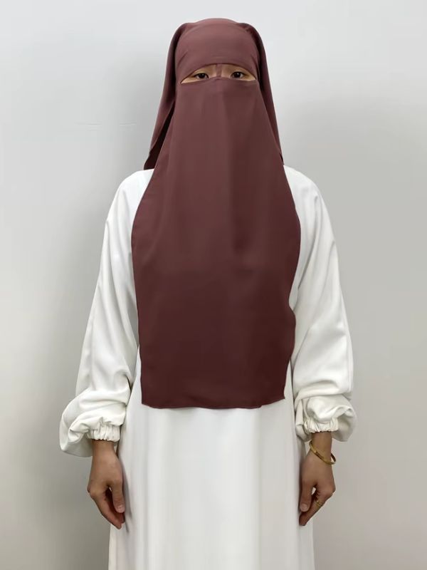 Niqab long en nida bois de rose Jardins de Grenade porté de face sur une abaya blanche, voile rectangulaire jusqu'au buste