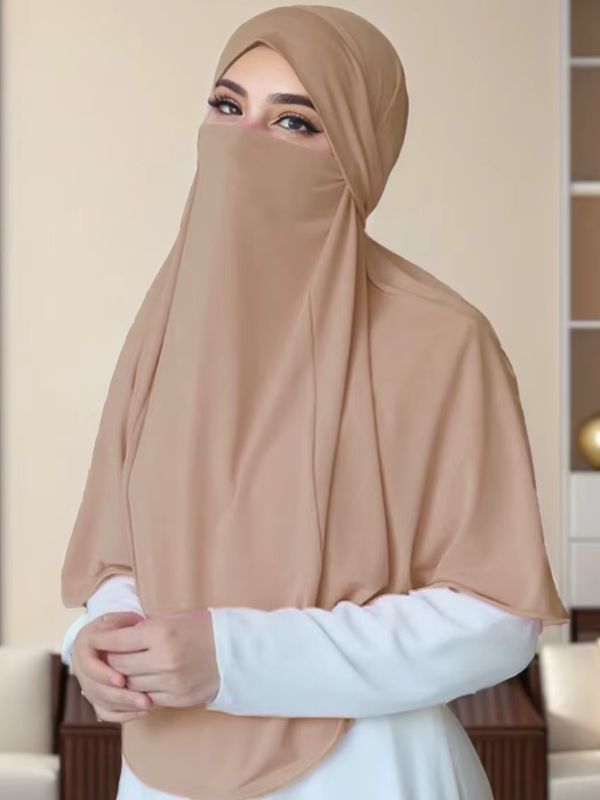 Niqab une pièce caramel Dune d'Arabie porté de face, capuche, voile du visage laissant les yeux dégagés et cape sur une abaya blanche