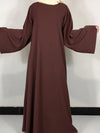 Une femme porte une robe abaya couleur chocolat