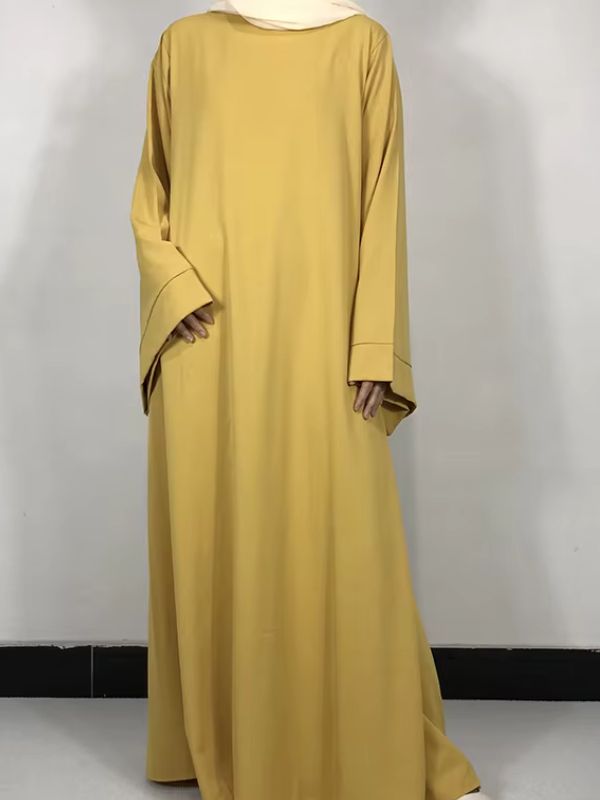 Une femme porte une abaya jaune