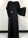 Une femme porte une robe abaya noir