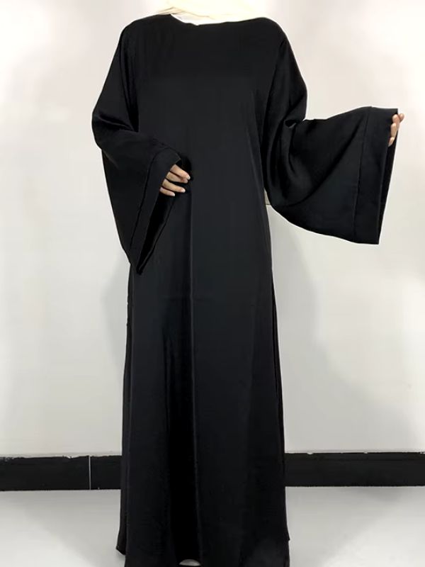 Une femme porte une robe abaya noir