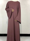 Une femme porte une abaya rose poudré