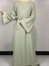 Une femme porte une robe abaya vert menthe