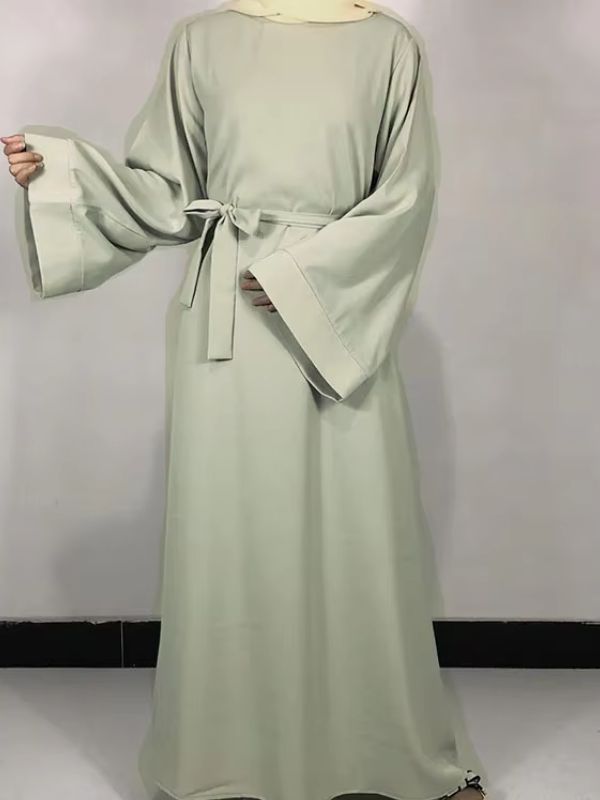 Une femme porte une robe abaya vert menthe