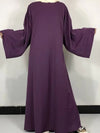 Une femme porte une abaya violet avec hijab