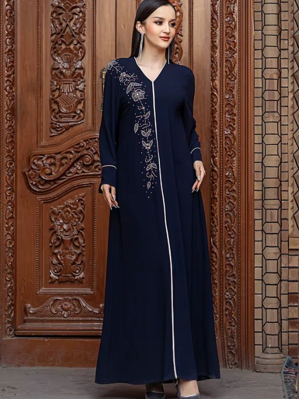 Une femme en robe djellaba devant une porte