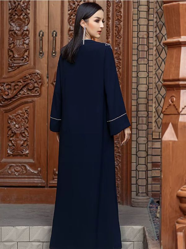 Une femme de dos en robe djellaba bleu nuit
