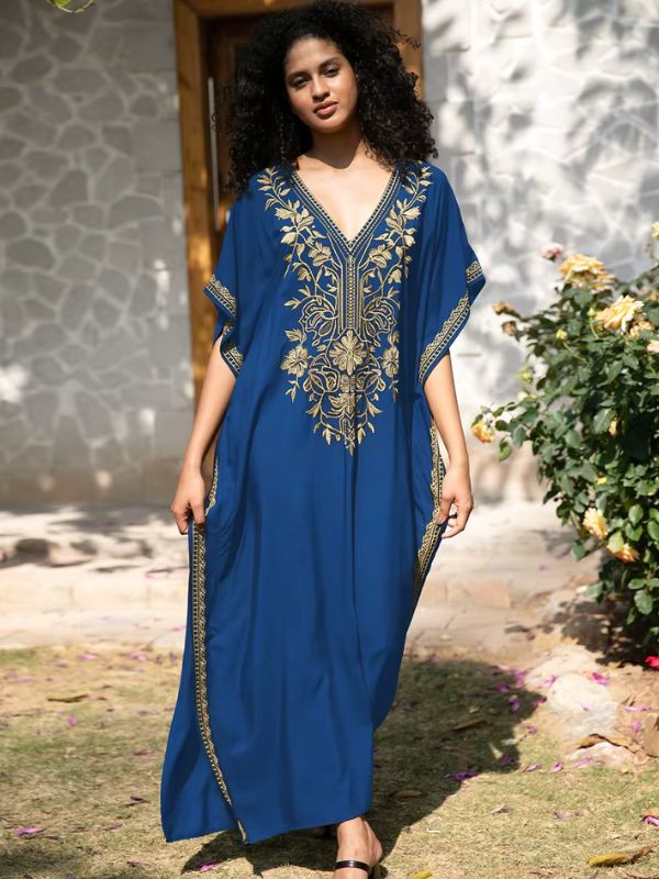 Femme posant de face dans une djellaba bleue royale ornée de motifs dorés