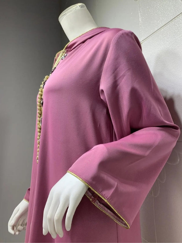 Vue latérale d&#39;un mannequin portant une djellaba violette avec des manches larges et des bordures dorées