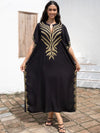 Robe djellaba noire ornée de broderies dorées, portée avec élégance