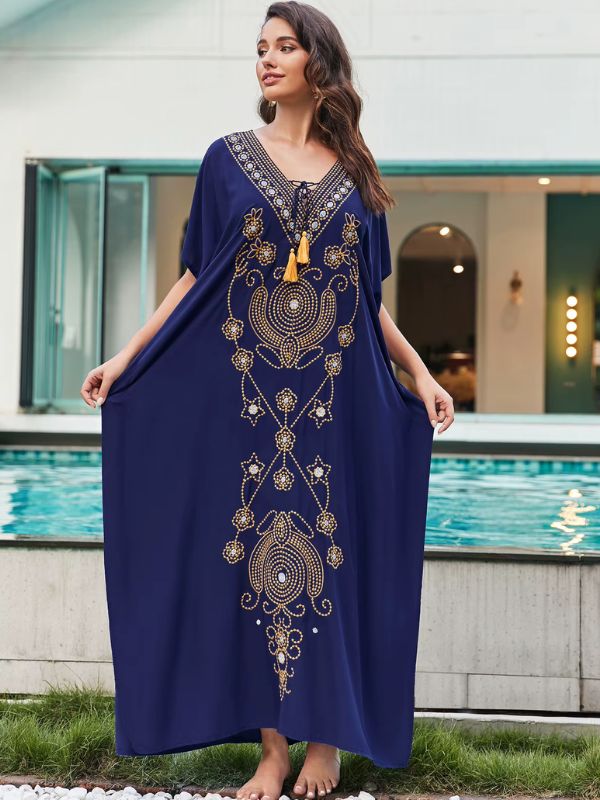Une femme porte une djellaba bleu marine avec motifs dorées