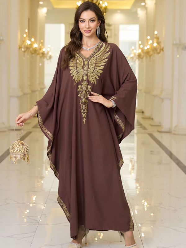 Femme portant une robe djellaba marron chocolat élégamment décorée de broderies dorées.