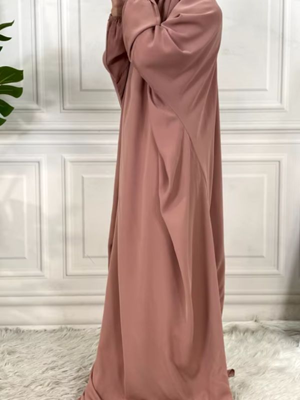 Une femme porte une robe jilbab rose