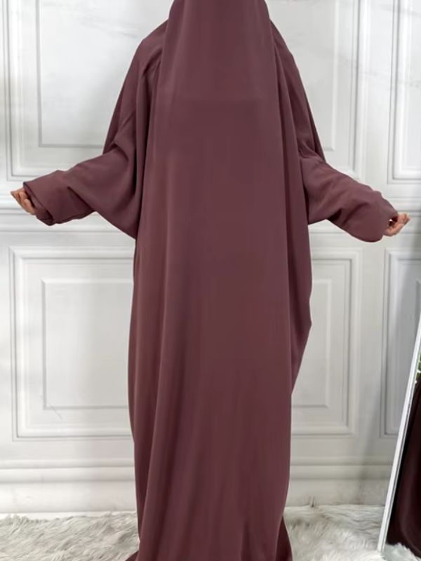 Une femme musulmane porte une robe jilbab violette