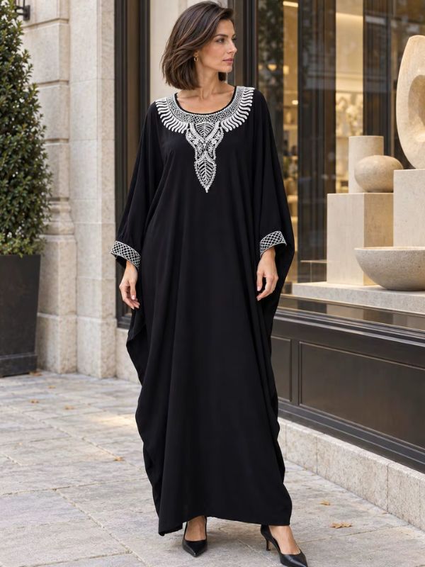 Robe marocaine traditionnelle noire, plastron brodé de palmes ivoire et poignets en treillis brodé, vue de face